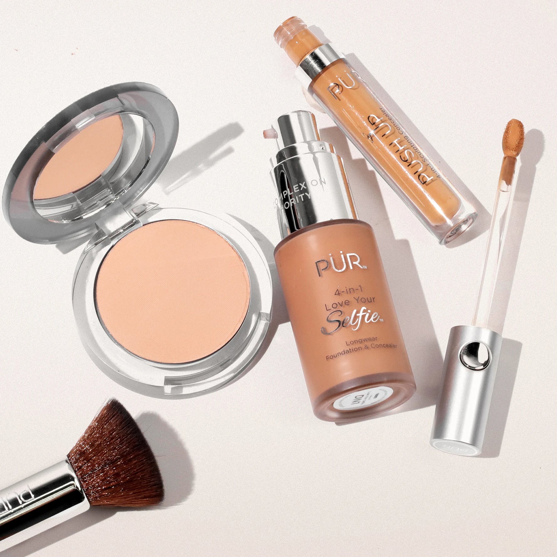 4-in-1 Sculpting Concealer Complexion Products against beige background