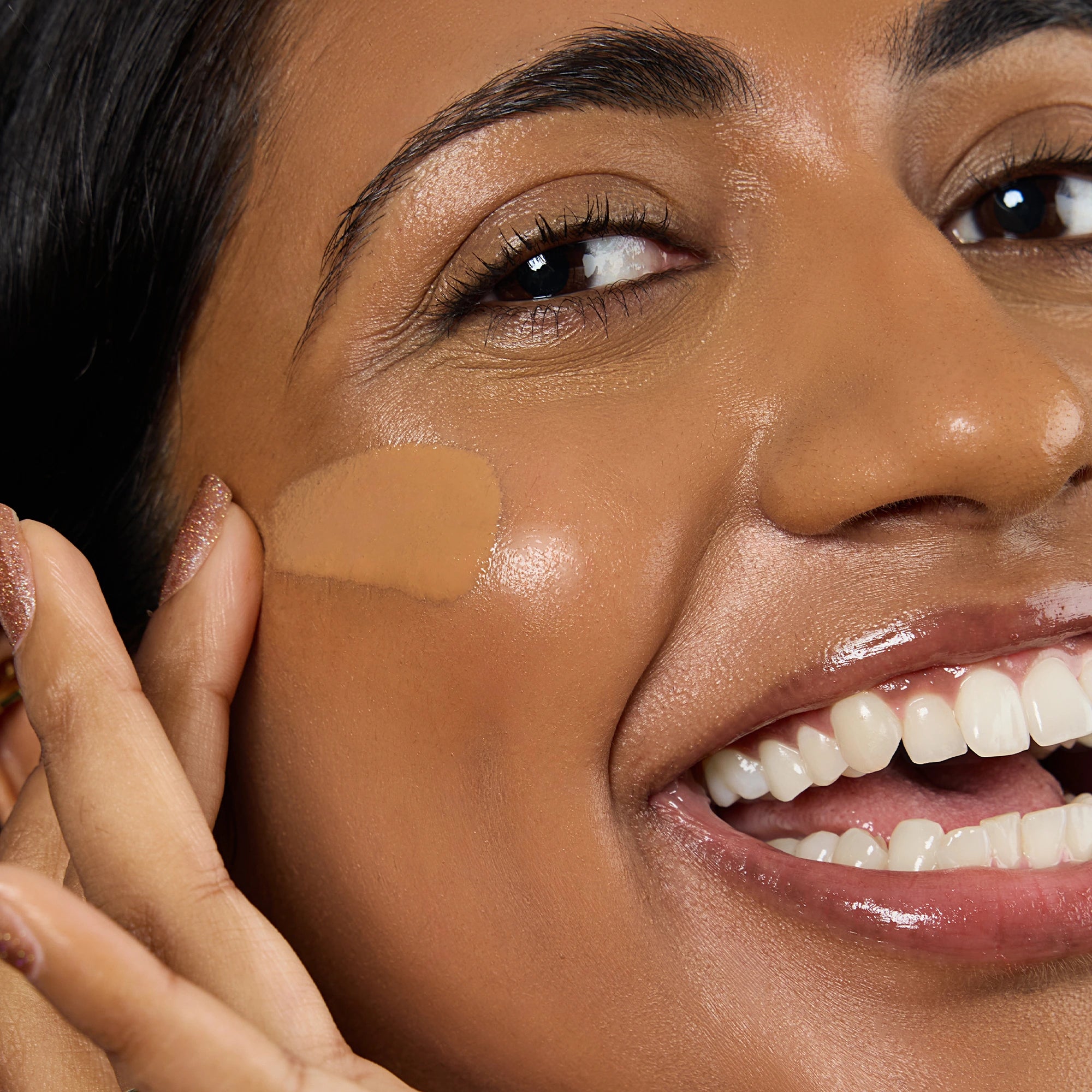 Close-up of a woman applying a beige concealer stick to her face Shade DP3 #dp3