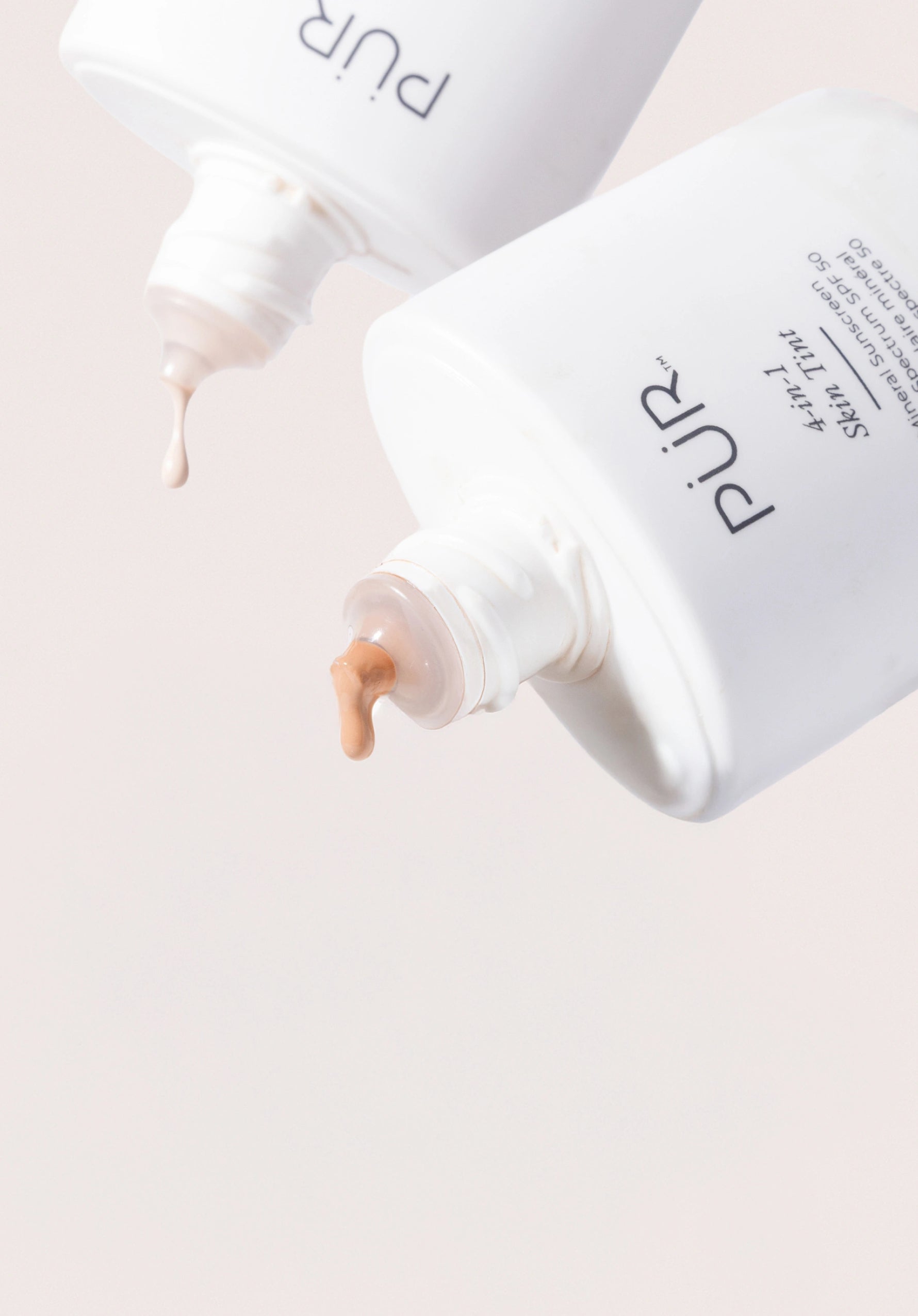 Skin Tint - Back in Stock: Two Skin Tint bottles dripping product against cream background (mobile)